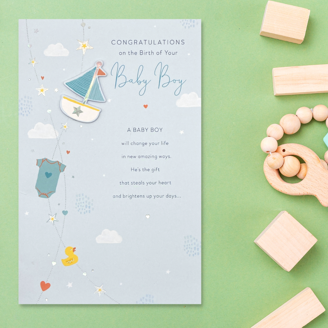 Front image of baby boy card with heartfelt verse, decoupage boat and baby clothes