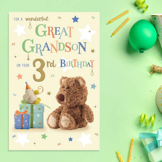 Cream card with Barley Bear character looking at gifts with multicolour text and gold foil text