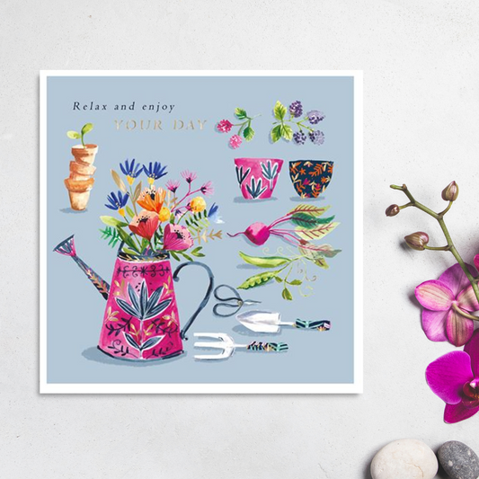 Blue square card with a floral watering can and gardening accessories