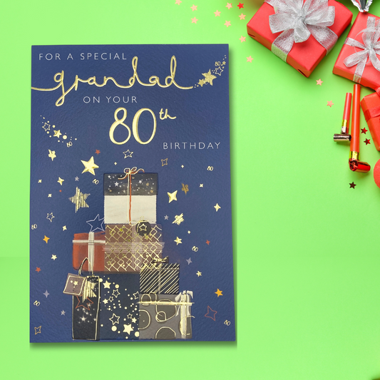 navy card with stacked gifts and gold foil text and stars