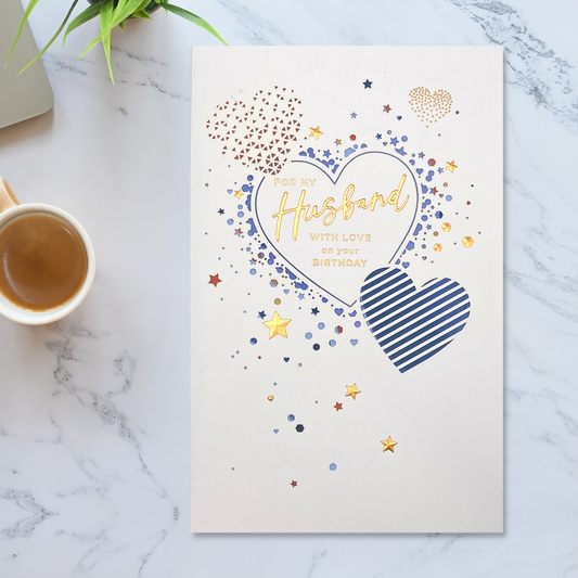 White card with heart shape cut outs to reveal blue card inside and gold foil details