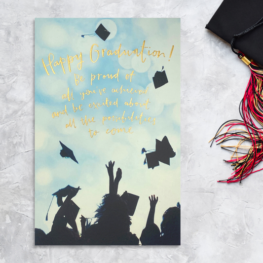 Front image showing graduate silhouette throwing hats off with gold foil text
