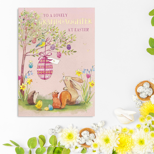 Pink card with woodland animals looking at easter egg hanging in tree