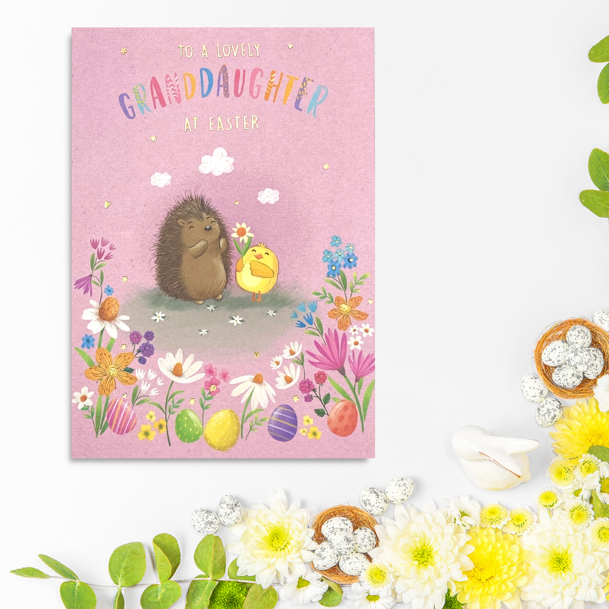 Pink card with sketched hedgehog and chick among flowers and easter eggs