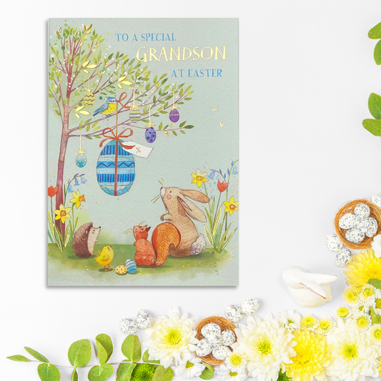 Blue card with woodland animals looking at Easter egg hanging in tree
