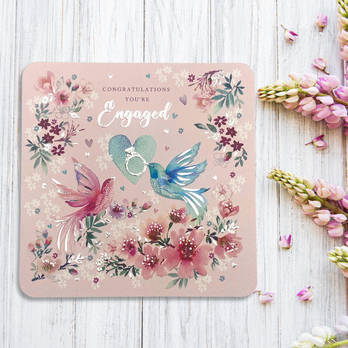 Front image of square card with pink background and pink and blue birds surrounded by flowers