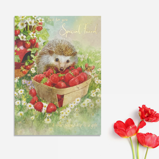 Cute hedgehog with a punnet of strawberries in the meadow