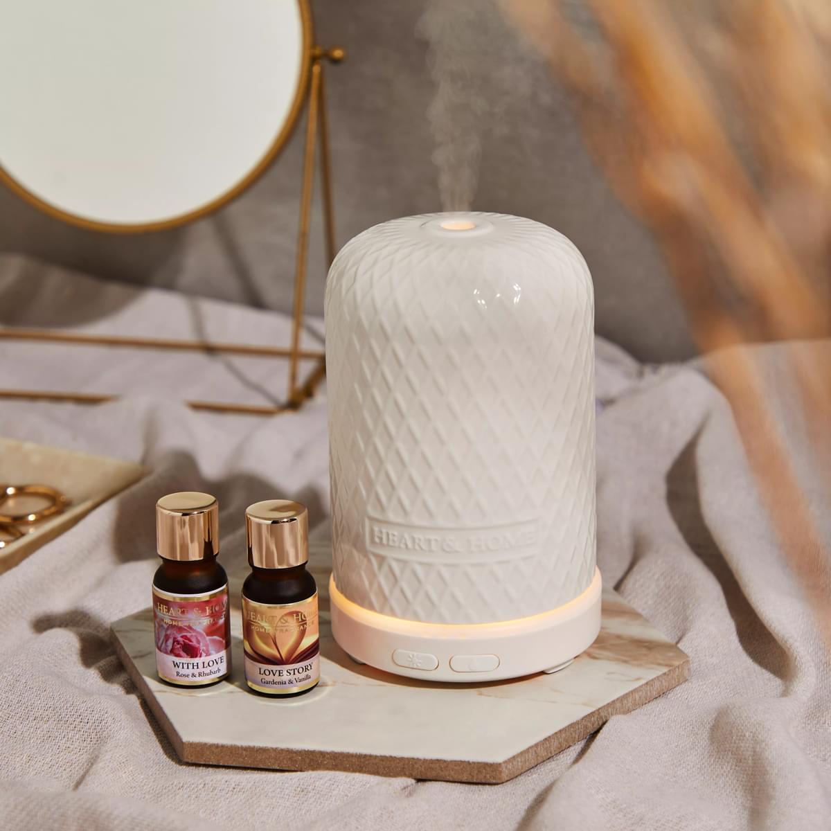 Lifestyle image with electric aroma diffuser and selection of oils