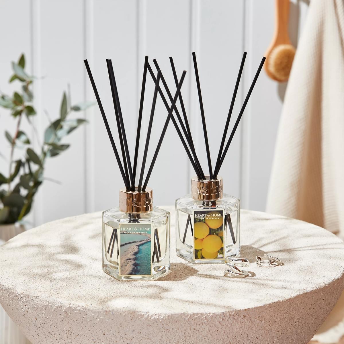 Lifestyle image with two reed diffusers on table