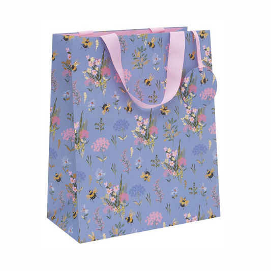 Powder blue gift bag with bees and meadow flower pattern and pink ribbon handles