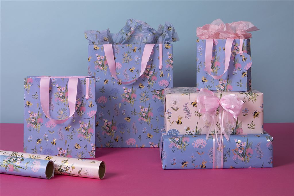 Lifestyle image with collection of matching blue bees gift bags and wrap