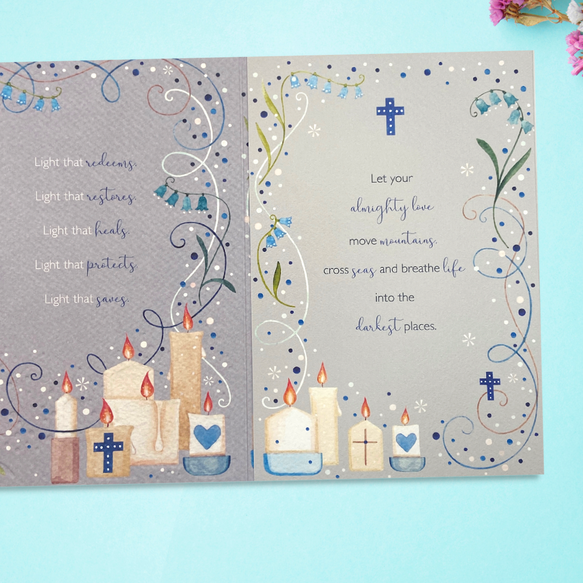 Inside image showing two pages with verse and decorated card with flowers and candles