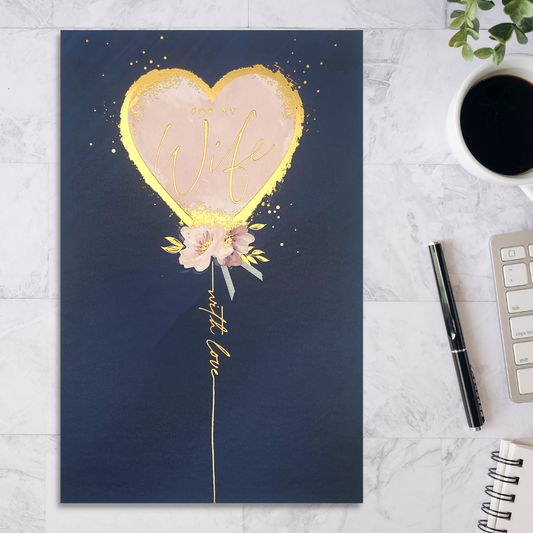 Navy card with pink balloon with gold foil border and add on floral decoration.