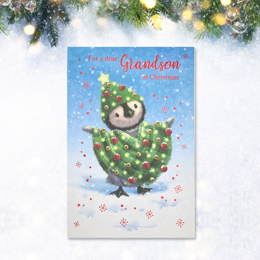 Penguin dressed in Christmas tree shaped blanket in snow