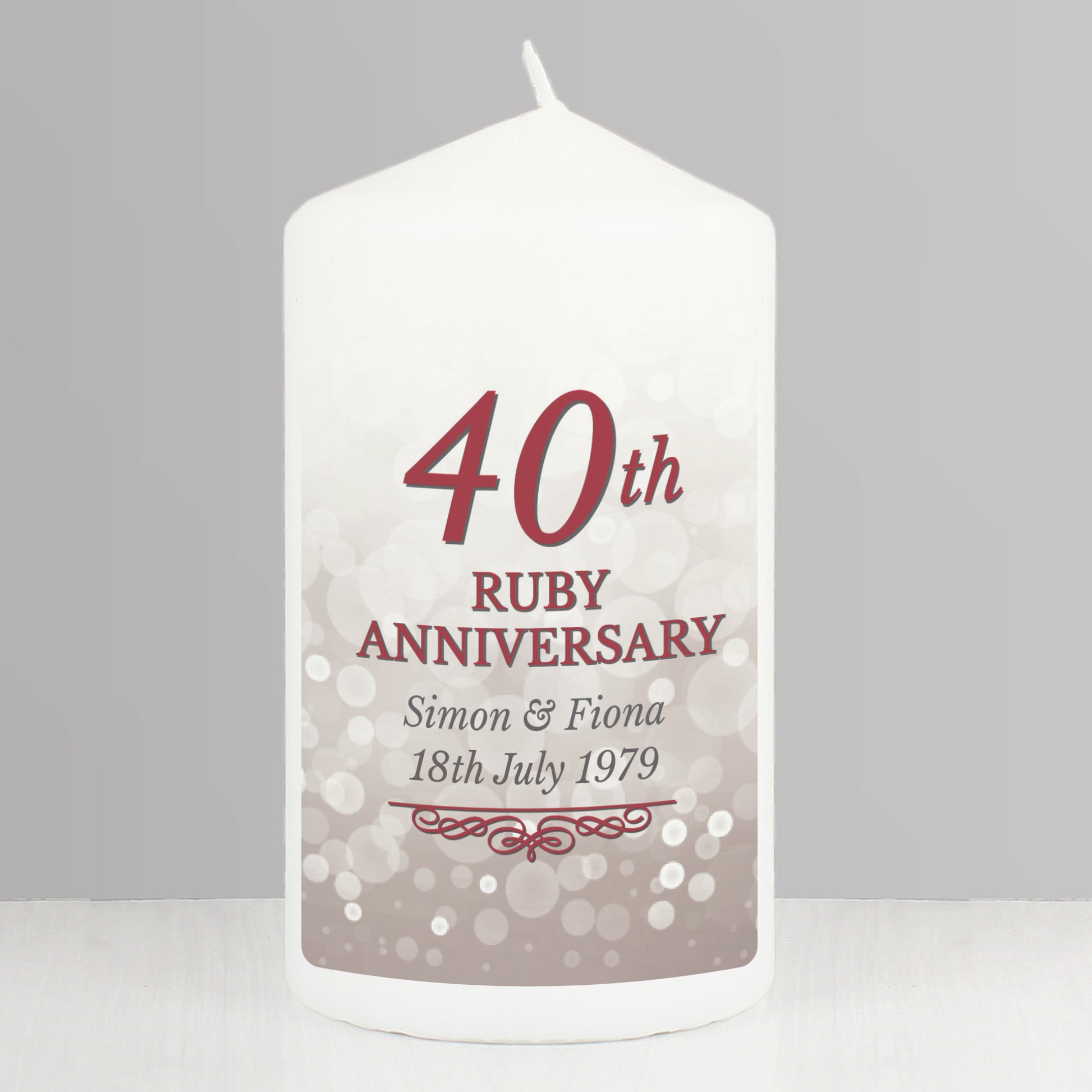 White candle with '40th Ruby Anniversary' text and personalized names on a grey background