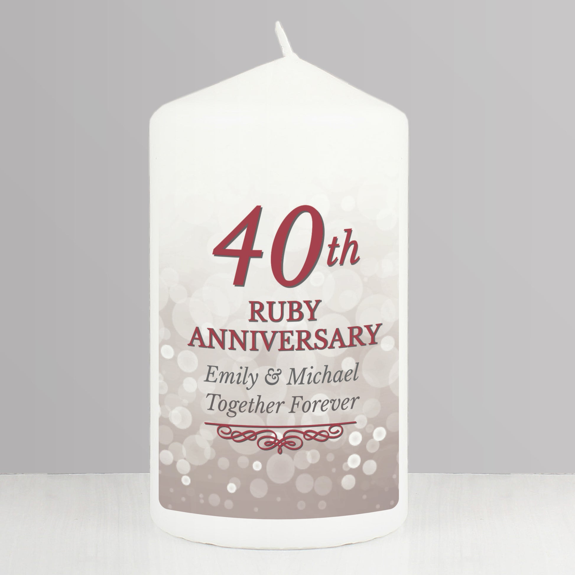 White candle with '40th Ruby Anniversary' text on a grey background