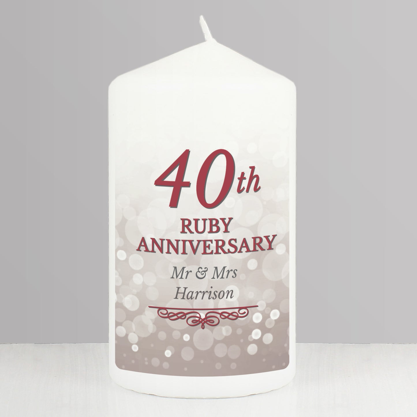 White candle with '40th Ruby Anniversary' text on a grey background