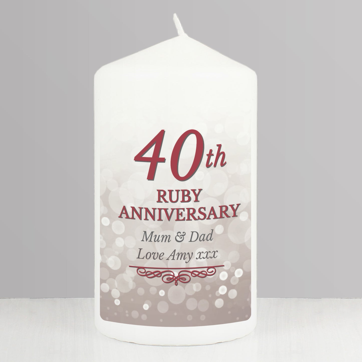 White candle with '40th Ruby Anniversary' text on a grey background