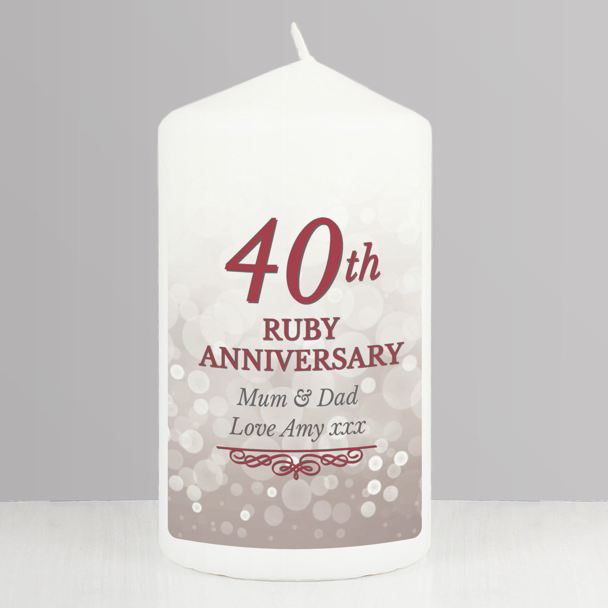 White candle with '40th Ruby Anniversary' text on a grey background