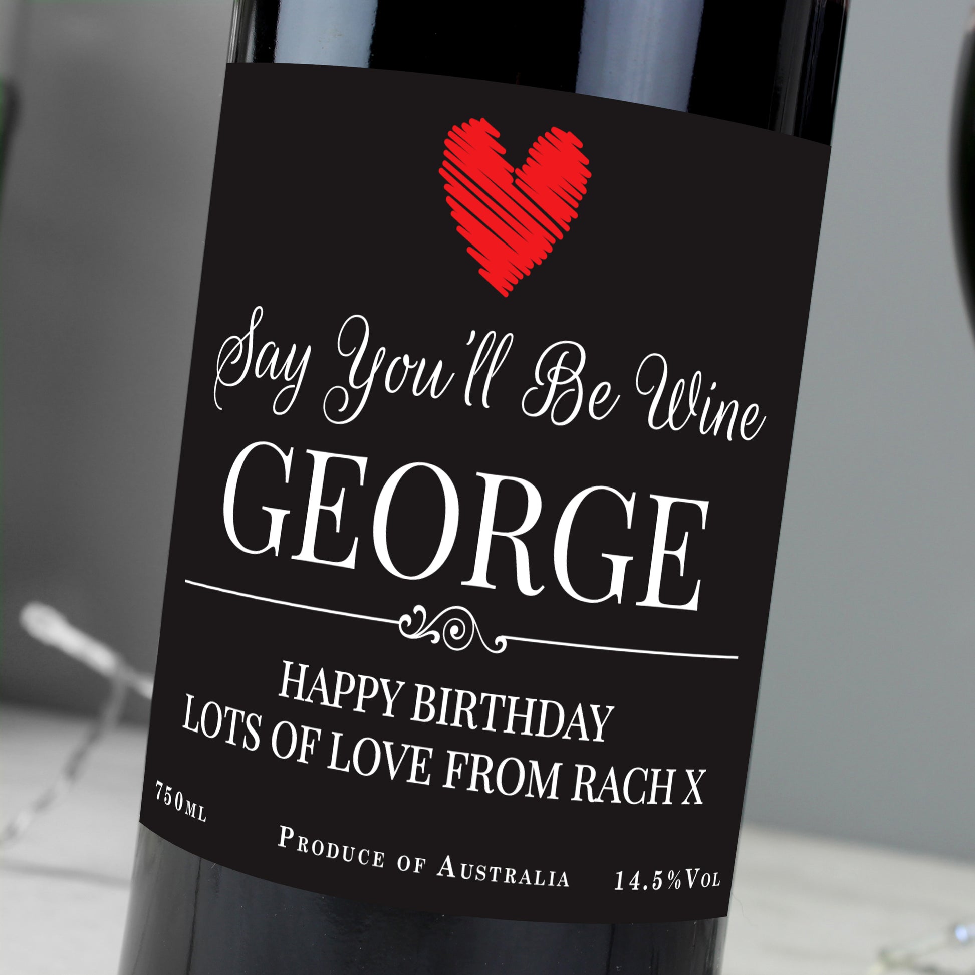 Wine bottle with a personalized label featuring a red heart and text.