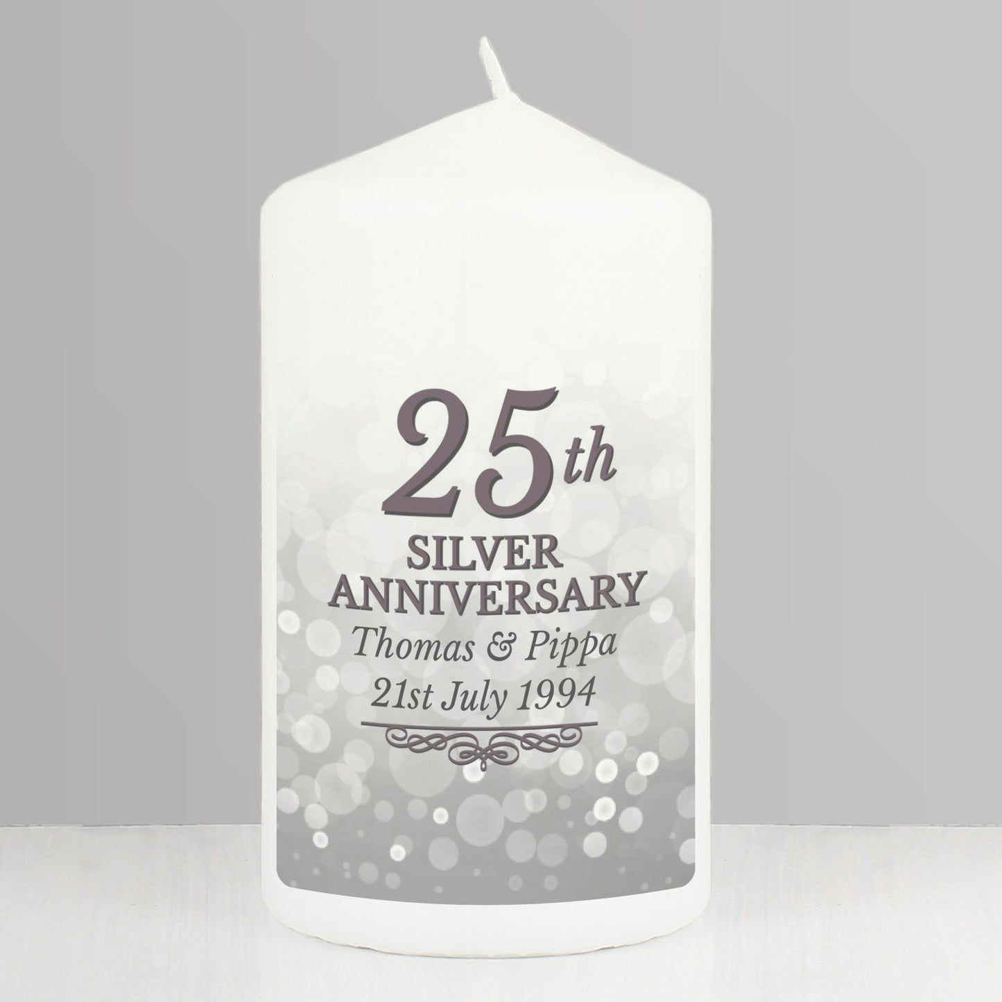 White candle with '25th Silver Anniversary' text on a grey background