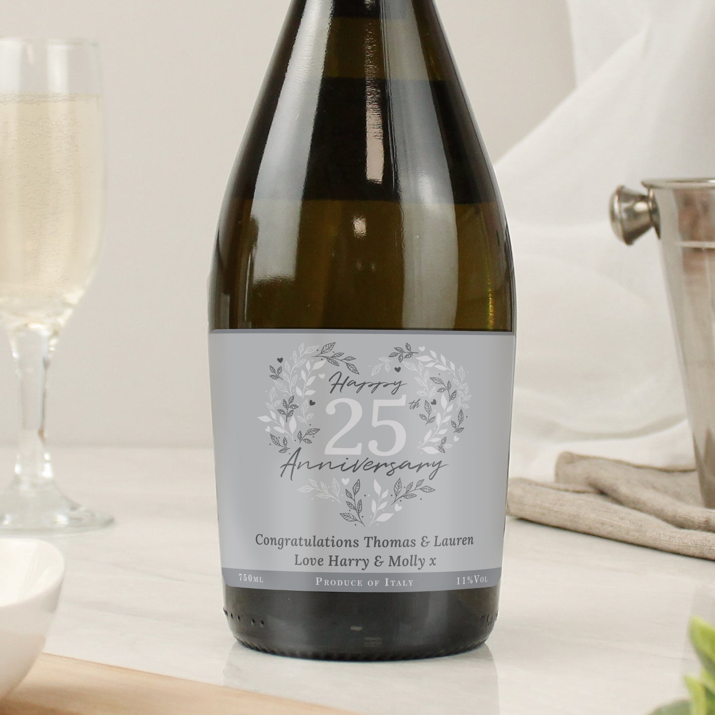 Wine bottle with a personalised label on a table with glasses.