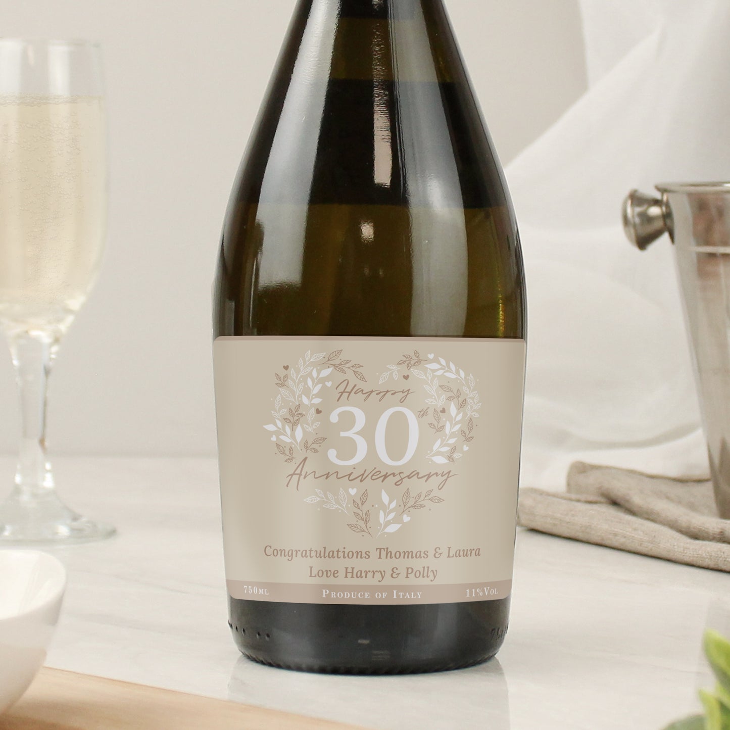 Wine bottle with a 'Happy 30th Anniversary' label on a table with glasses.