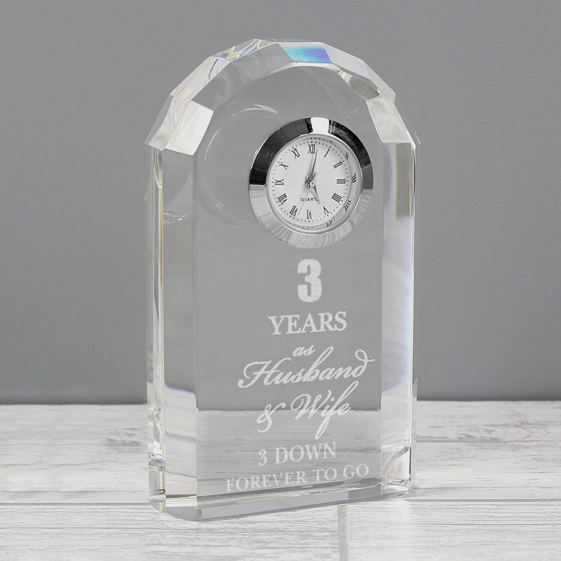 Crystal clock with engraved text on a grey background