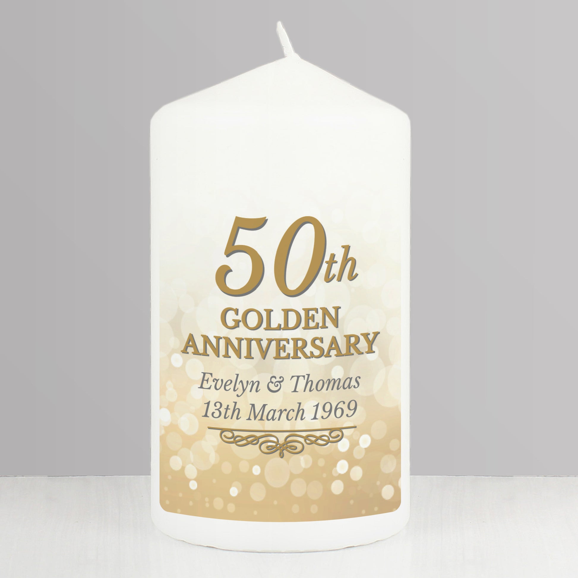 White candle with gold text '50th Golden Anniversary' on a grey background
