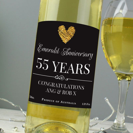 Bottle of white wine with a 'Sapphire Anniversary 45 Years' label next to a glass of wine.