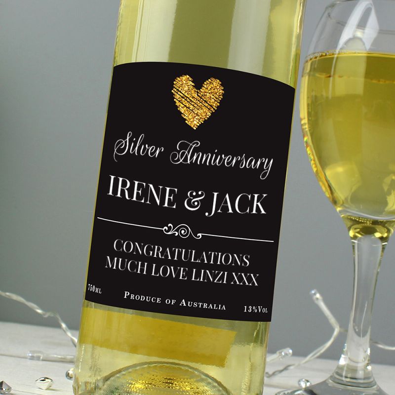 Bottle of white wine with a personalised label next to a glass of wine on a grey background