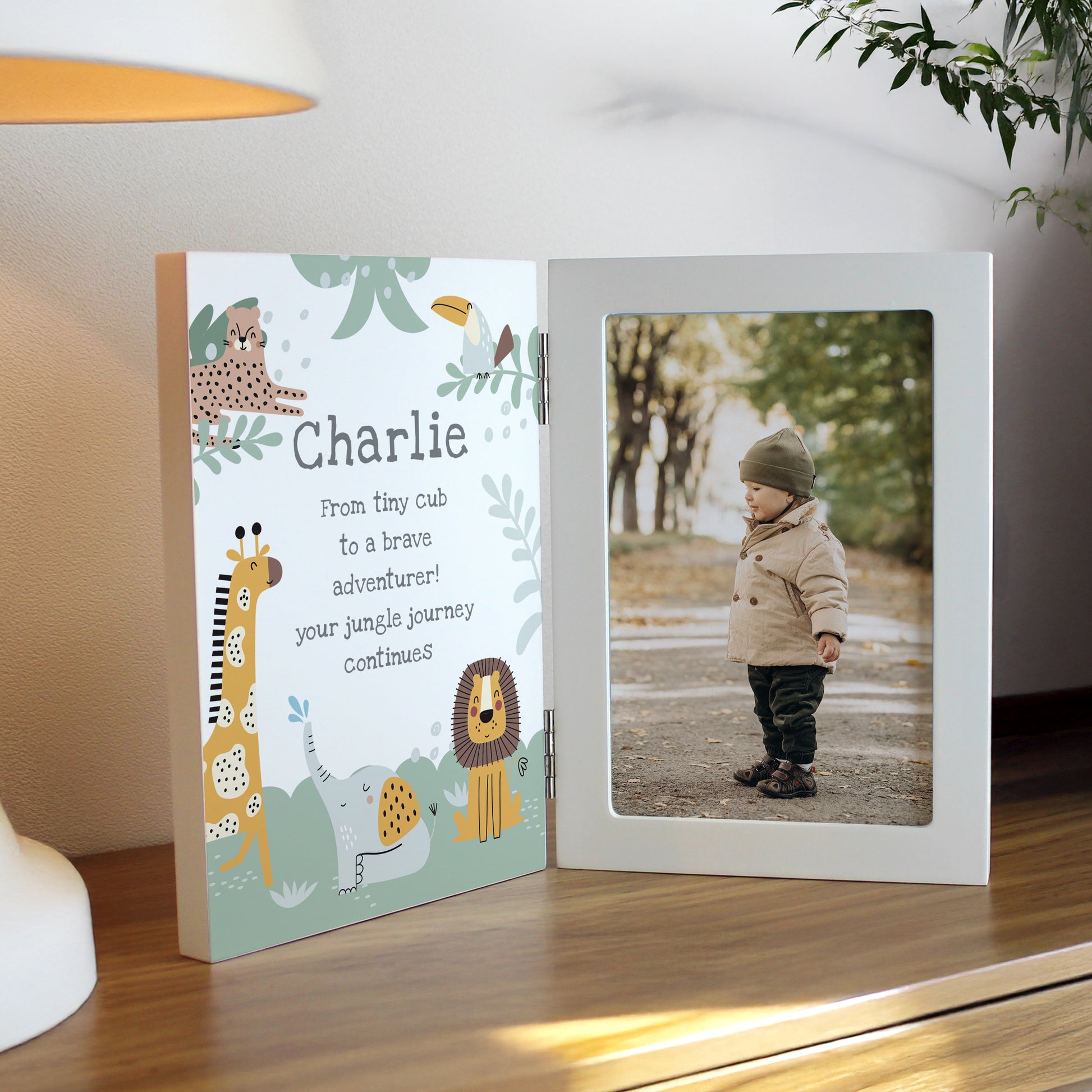 Personalised photo album with animal-themed cover and child's photo inside, placed on a wooden surface.