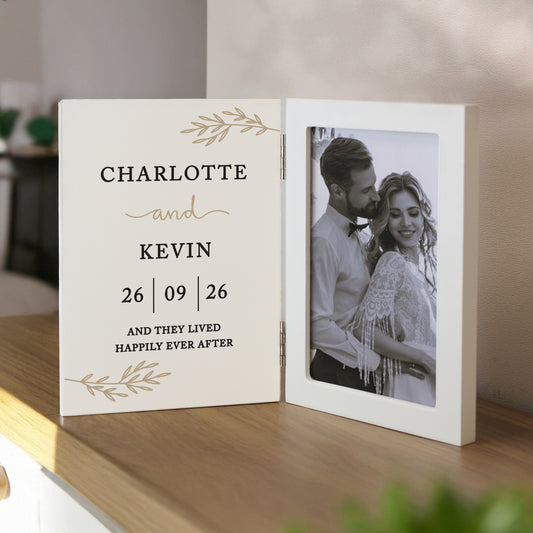 Personalised photo album with a couple's name and wedding date on a wooden surface.