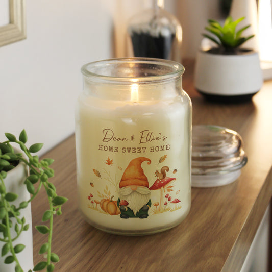 Personalised candle in a jar with a gnome design on a wooden surface