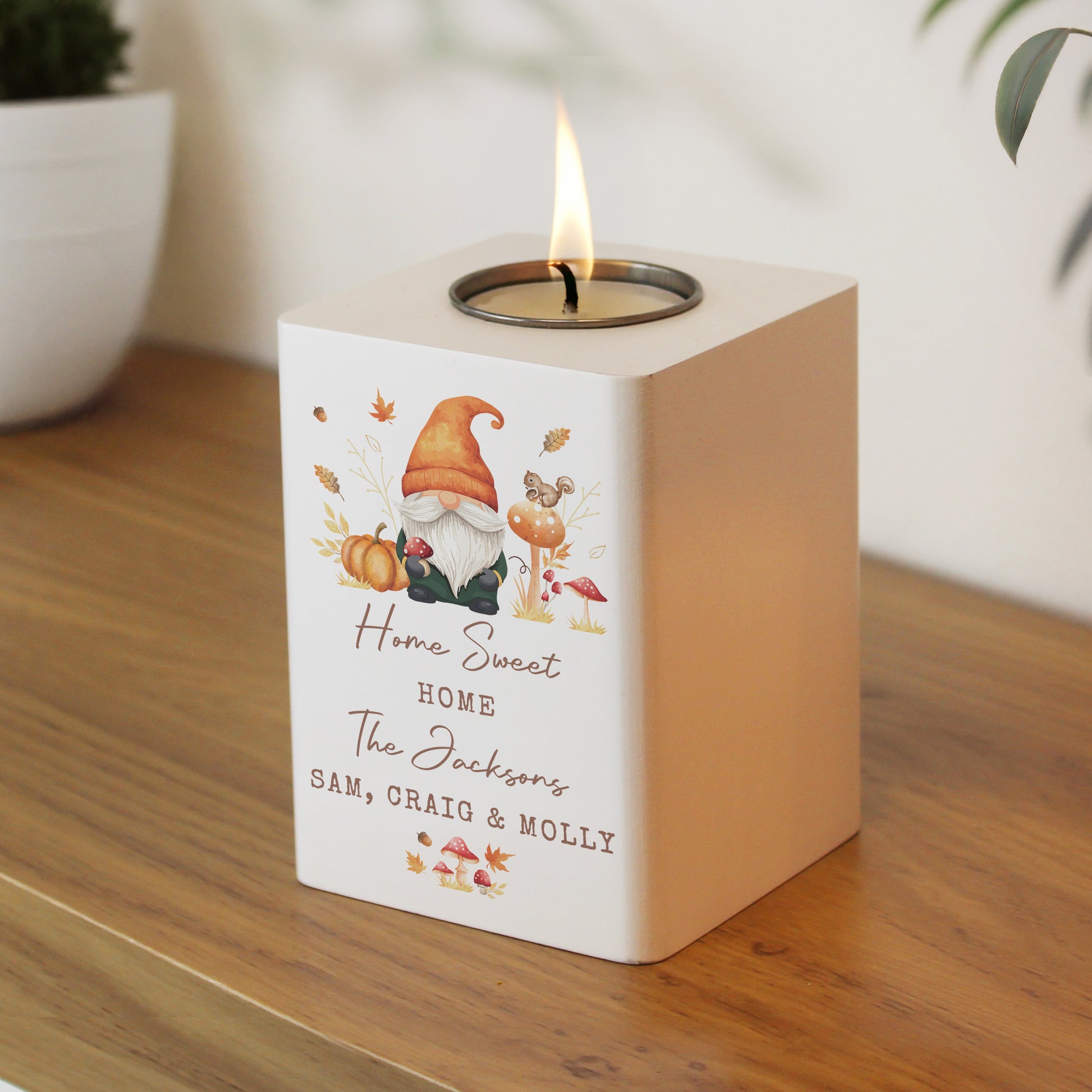 Candle holder with a gnome design on a wooden surface