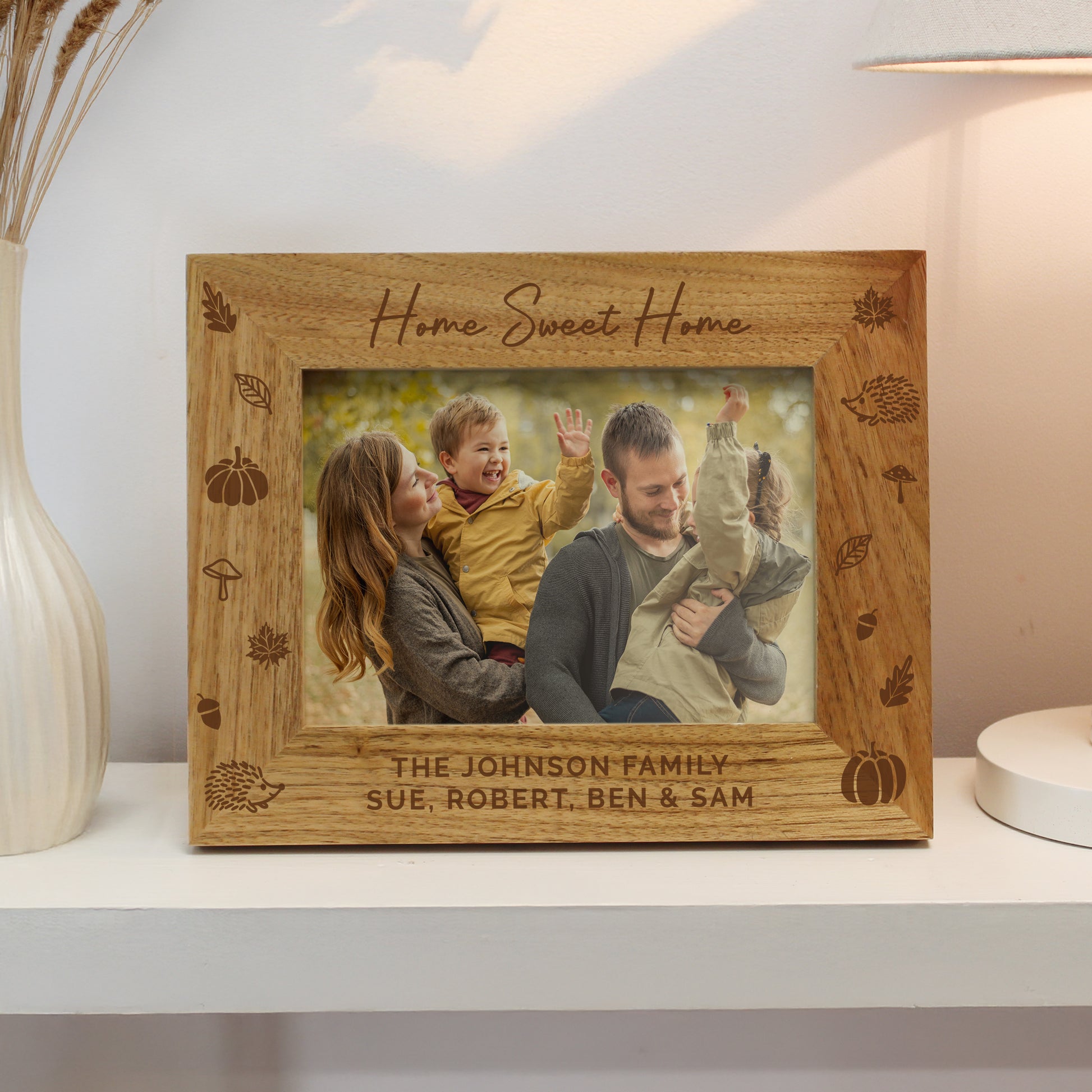 Personalised Autumn themed wooden photo frame with family photo and engraved text on a shelf.