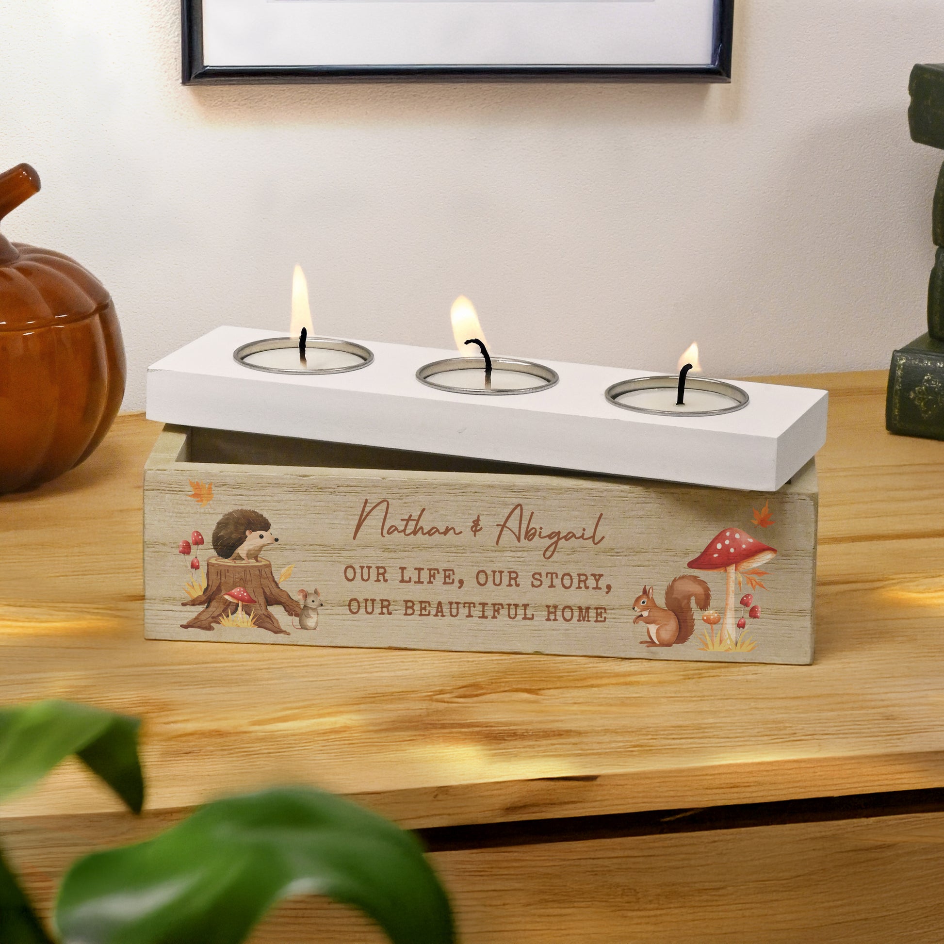 Wooden tea light holder with engraved text on a wooden surface.