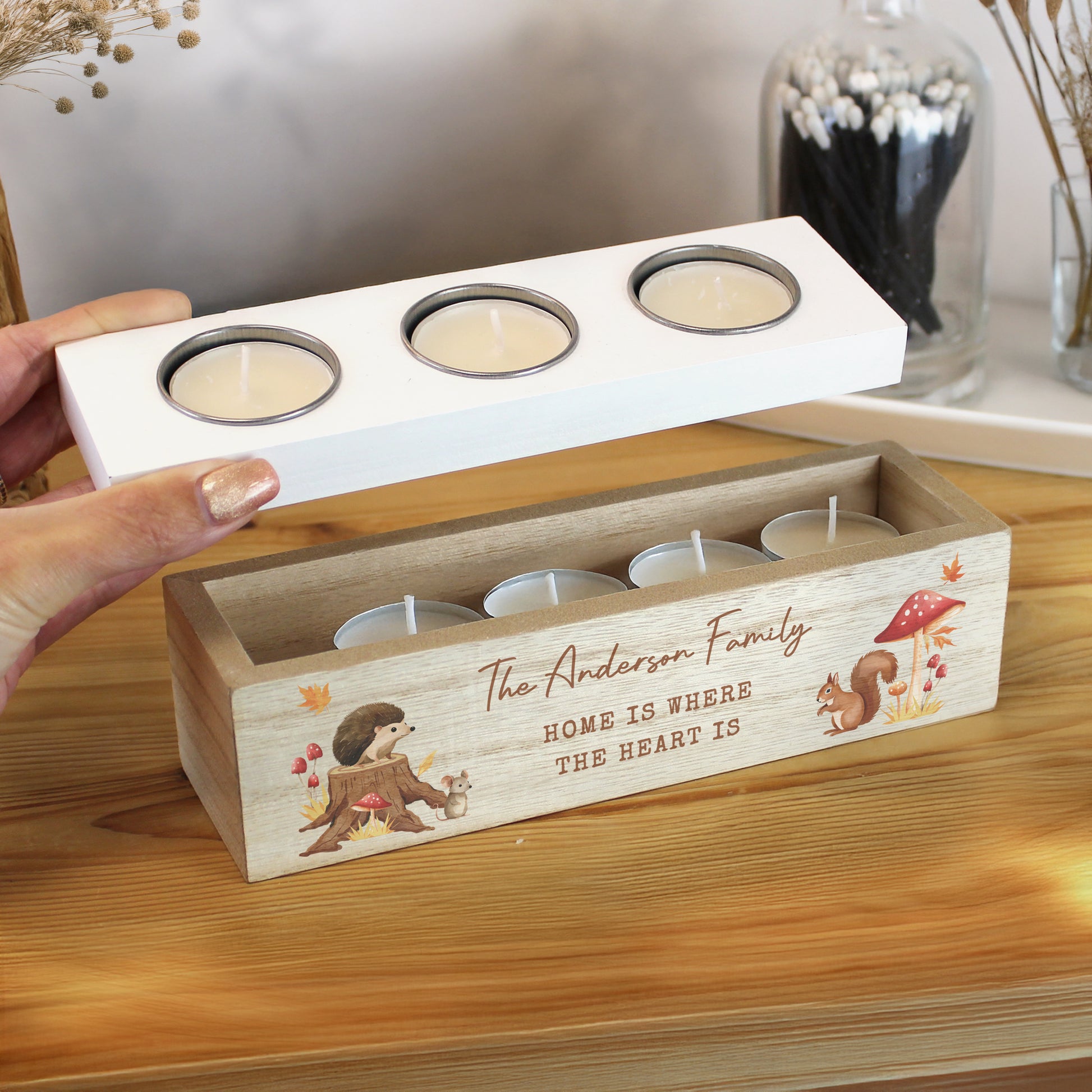 Wooden candle holder with tea light candles and autumn-themed graphics and personalised text on a wooden surface.