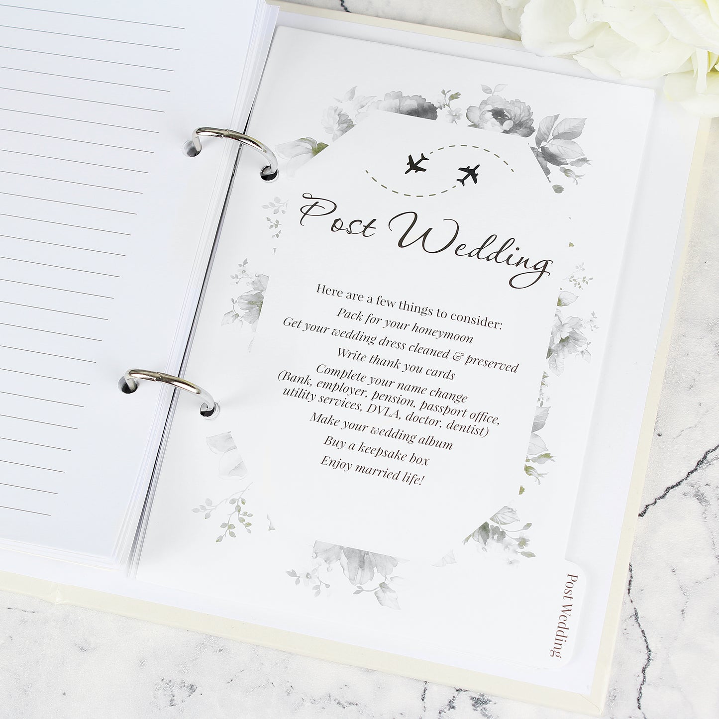 Notebook with a post-wedding checklist on a marble surface