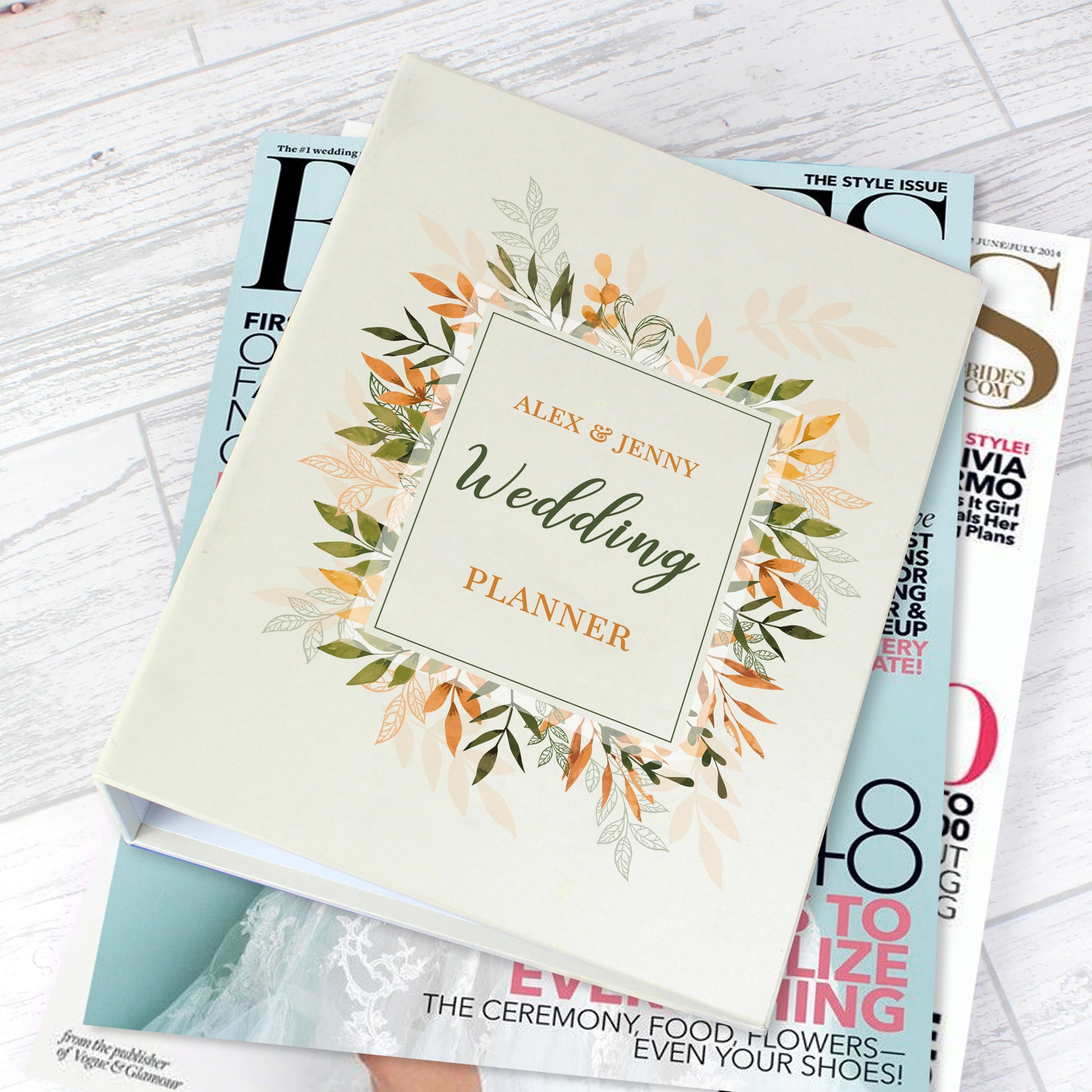 Wedding planner book with floral design on a stack of magazines