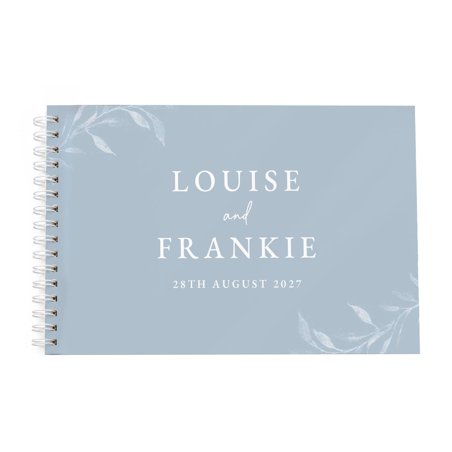 A personalised spiral-bound notebook with a dusty blue cover, featuring white text that reads 'LOUISE and FRANKIE' and the date '28TH AUGUST 2027', accented with delicate white floral illustrations in the corners. The notebook is bound with silver metal spirals on the left side, set against a plain white background.