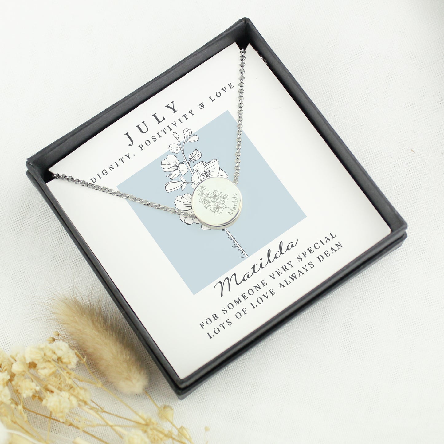 Silver necklace with floral design in a gift box on a white background