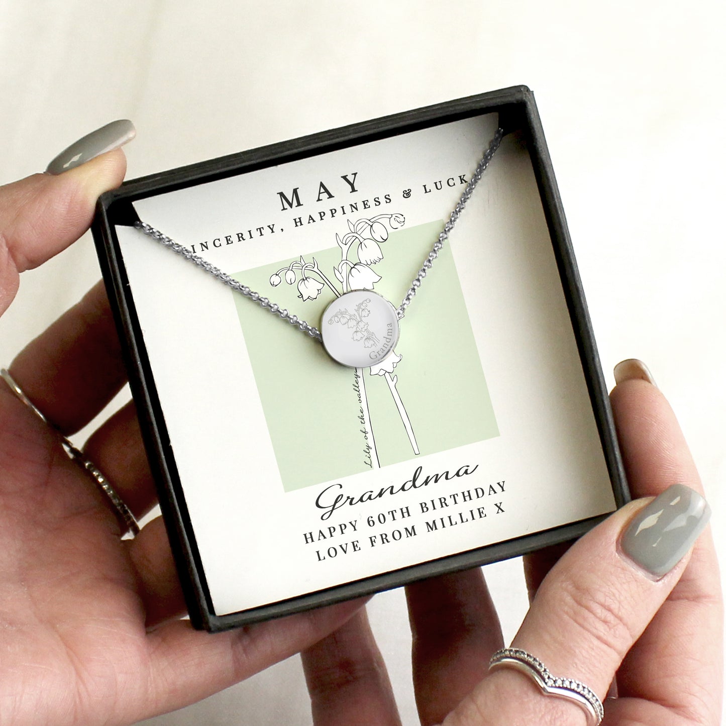 Necklace in a gift box with personalised message, held by a hand.