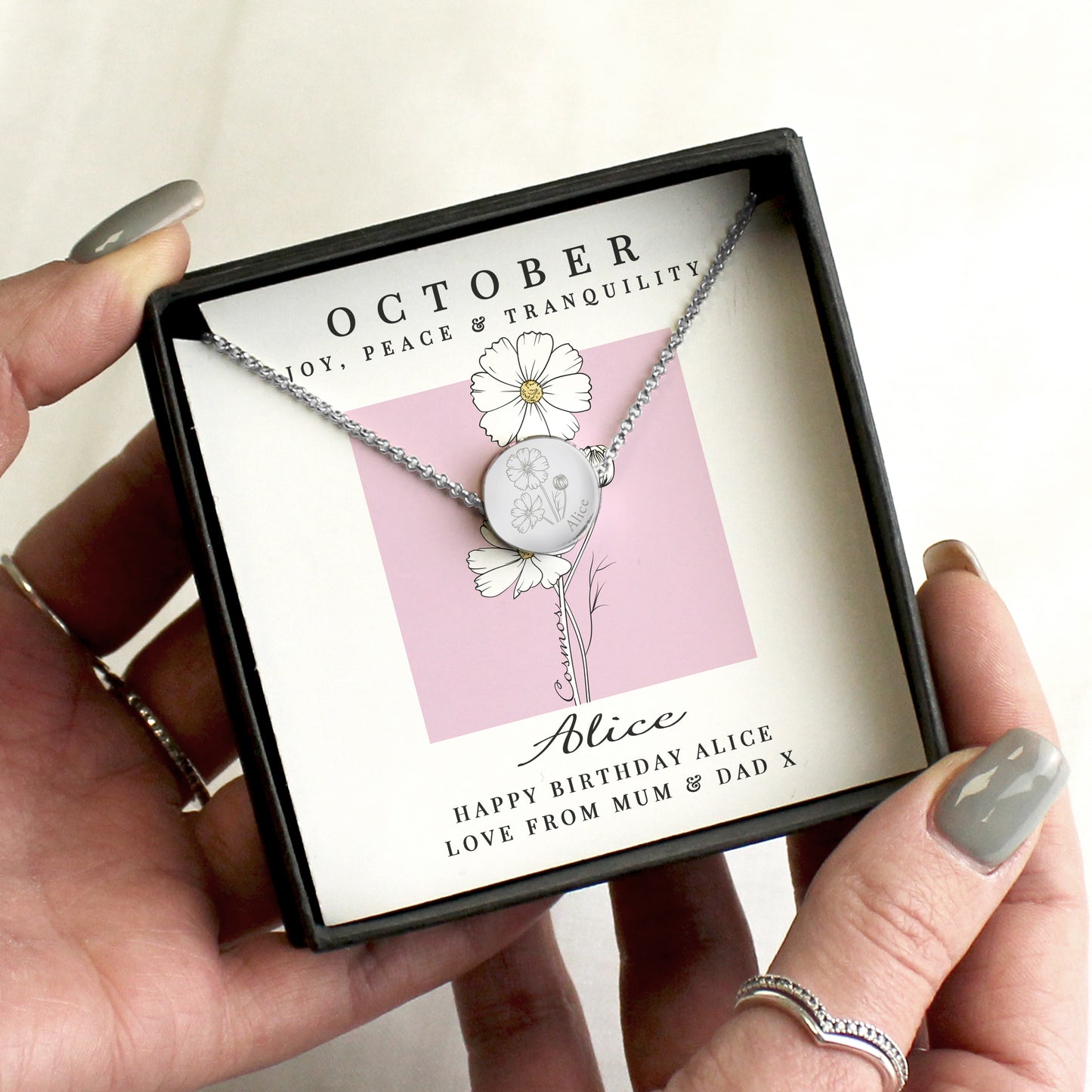 Necklace in a gift box with personalised message, held by a hand.