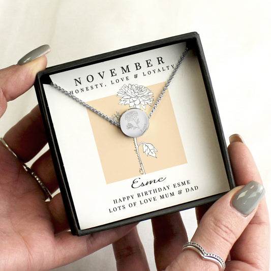 Necklace with engraved design held in a box with 'November' and 'Esme' text.