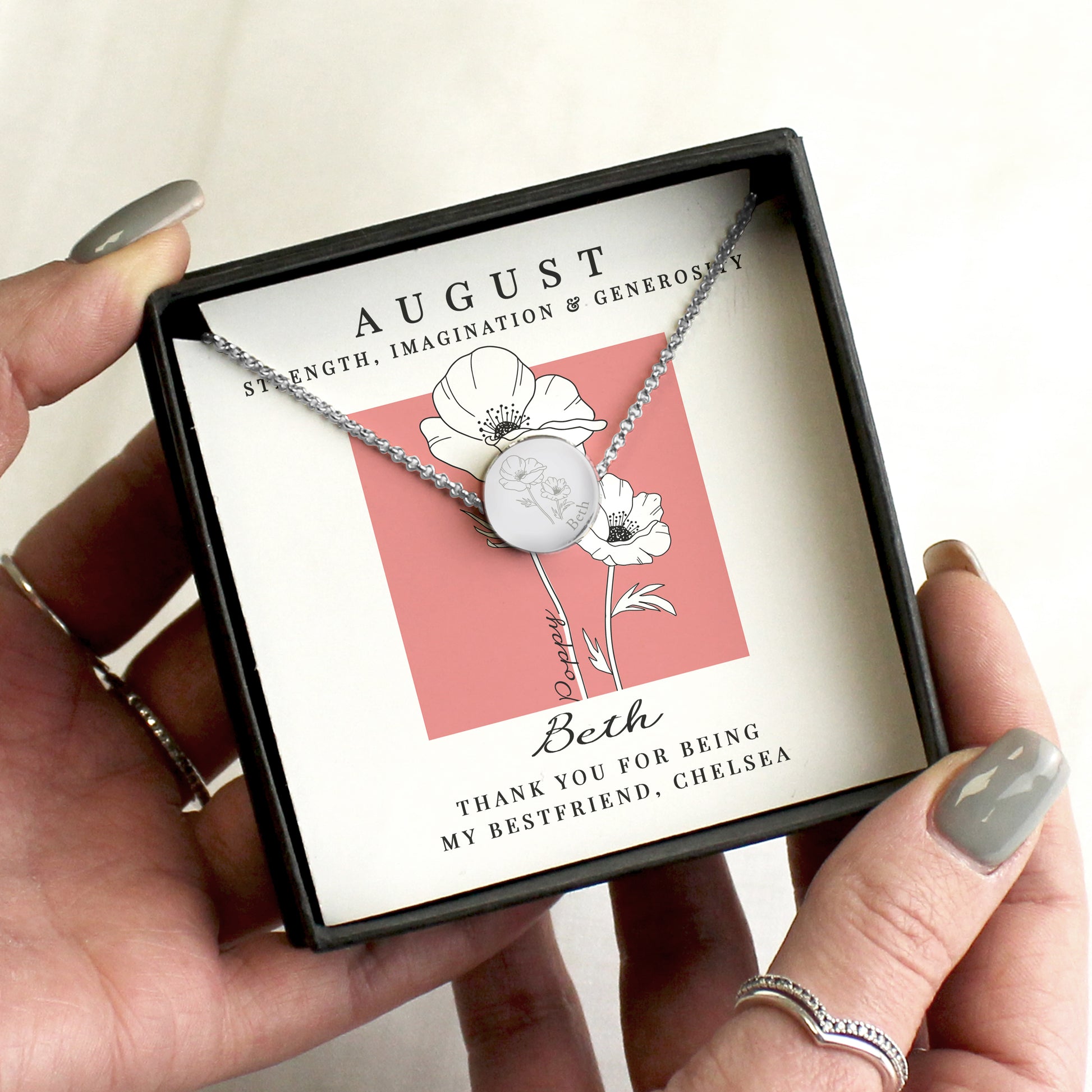 Necklace in a gift box with a personalised message card held by a person.