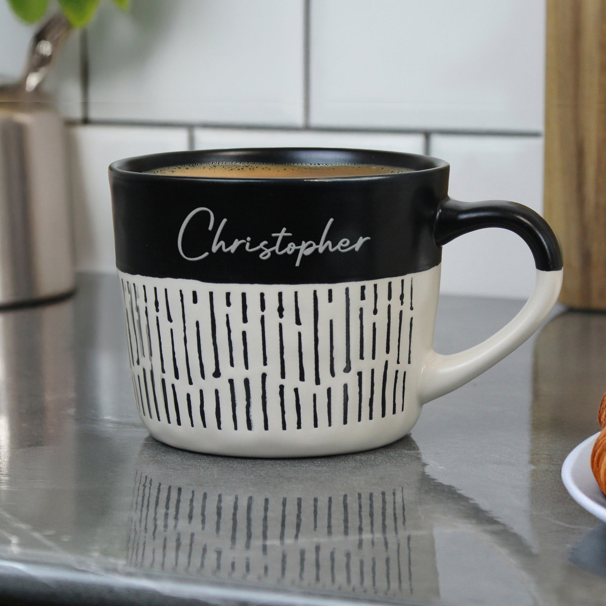 Personalised black and beige mug with 'Christopher' on a kitchen counter