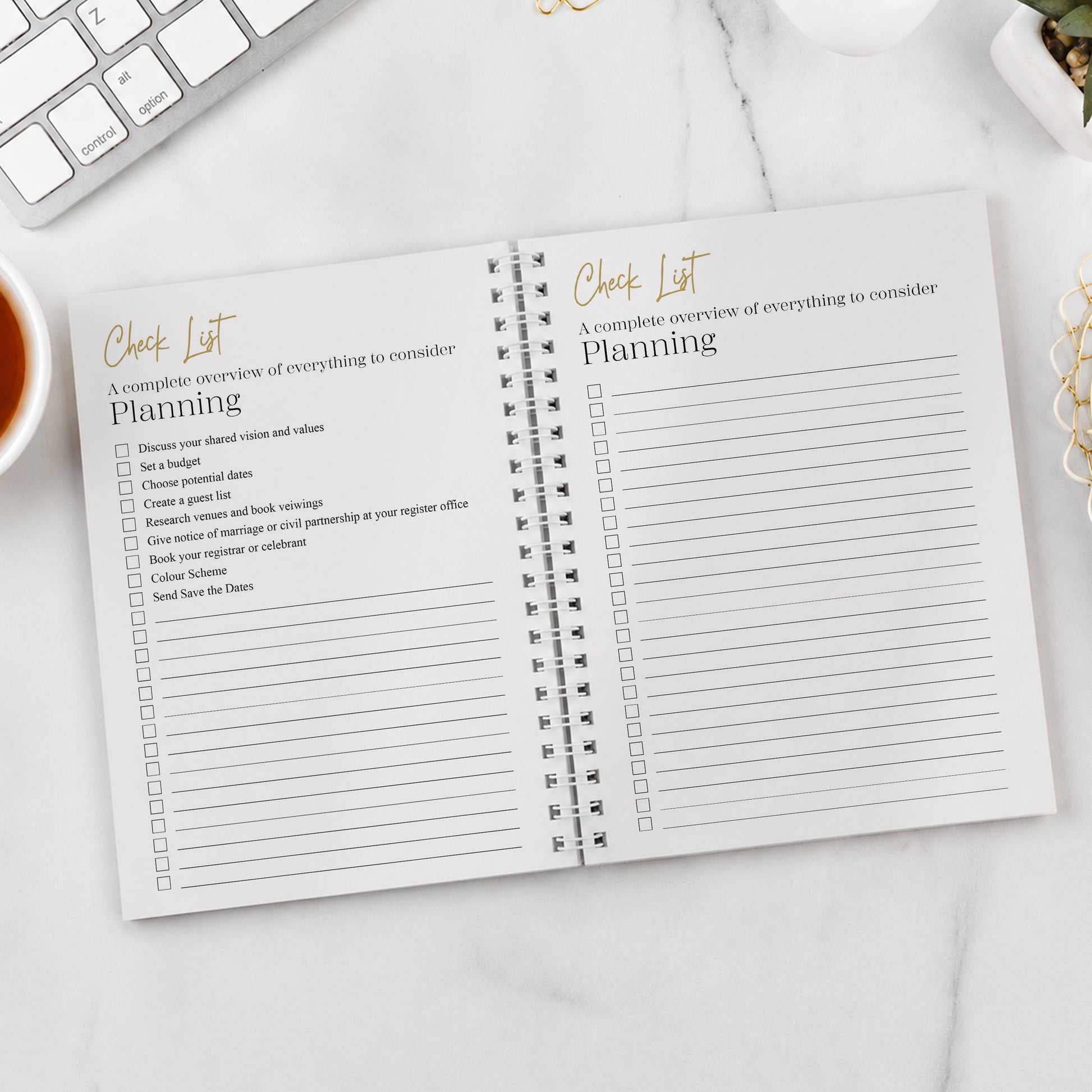 Open check list book on a desk with a keyboard and cup of tea in the background