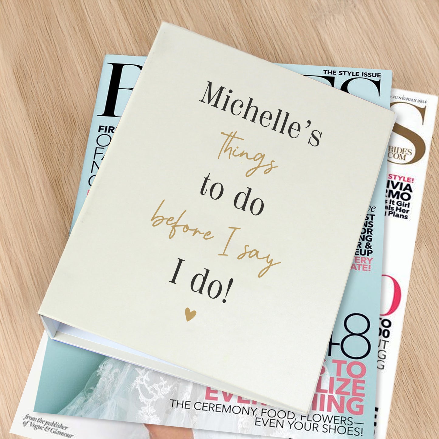 Book titled 'Michelle's things to do before I say I do!' on top of other books on a wooden surface
