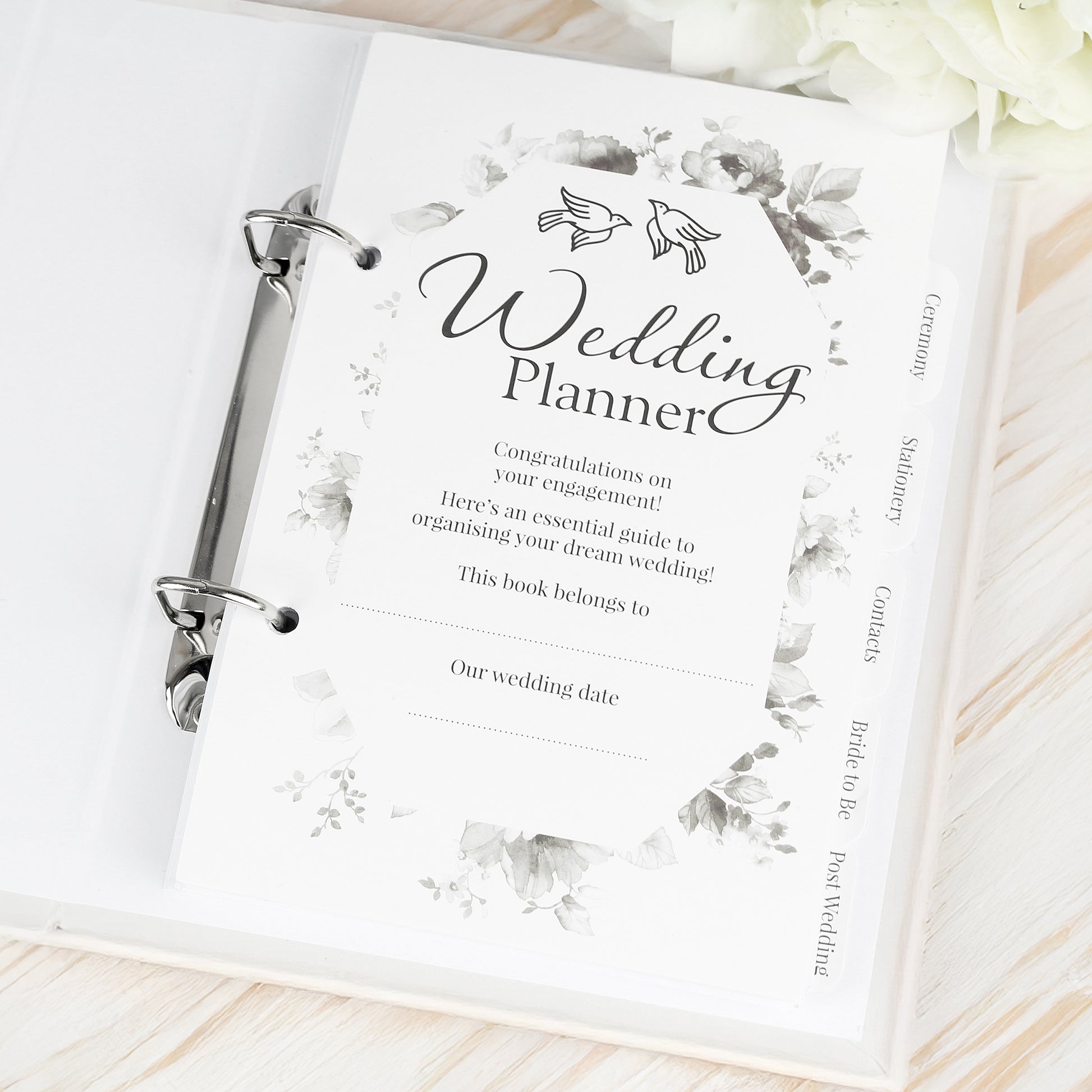 Wedding planner book with floral design on a wooden surface